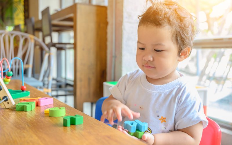 Asian preschool age play with colorful toy alone. Education game for kid. Baby learning and lifestyle.